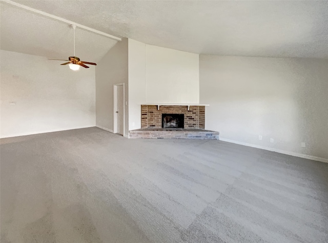 unfurnished living room featuring high vaulted ceiling, a brick fireplace, a textured ceiling, carpet flooring, and ceiling fan