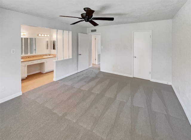 interior space featuring ceiling fan and light colored carpet