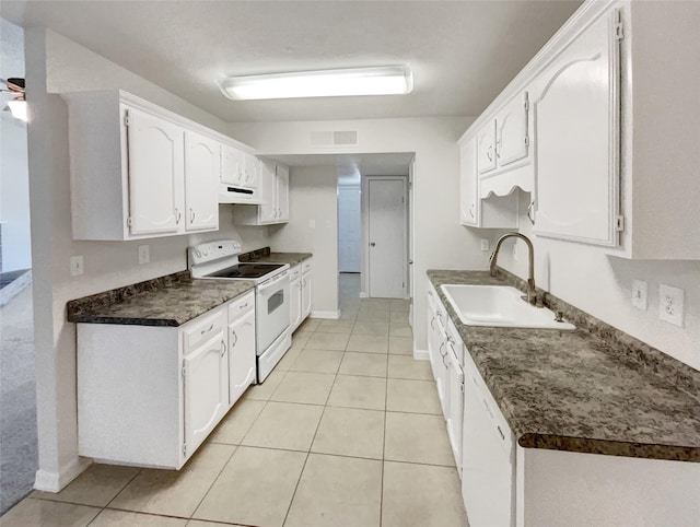 kitchen with light tile patterned flooring, a sink, white cabinetry, white appliances, and dark countertops