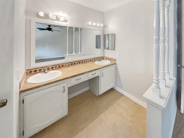 bathroom with decorative backsplash, double vanity, a sink, and baseboards