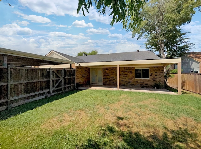 back of house with a yard and a patio