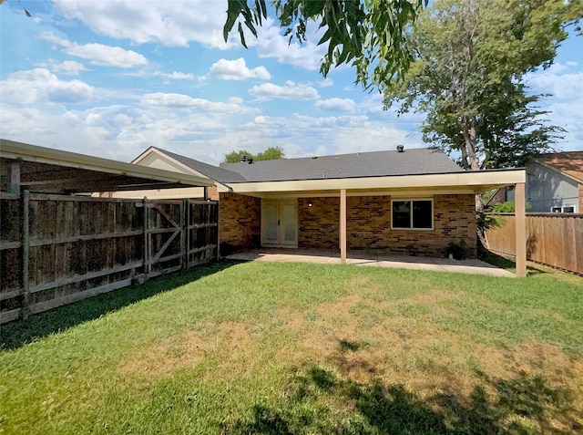 back of property with a lawn, a fenced backyard, and a patio