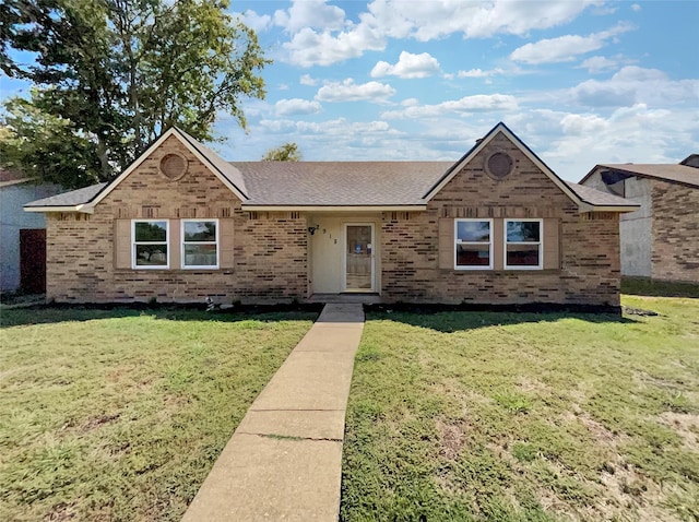 ranch-style home featuring a front lawn, brick siding, and roof with shingles