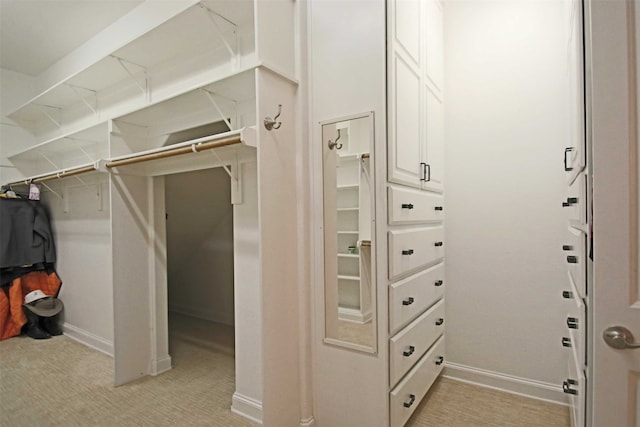 walk in closet featuring light colored carpet