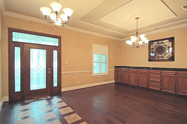 entrance foyer featuring an inviting chandelier, crown molding, and dark hardwood / wood-style flooring