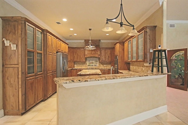 kitchen featuring light stone counters, kitchen peninsula, stainless steel appliances, decorative light fixtures, and crown molding