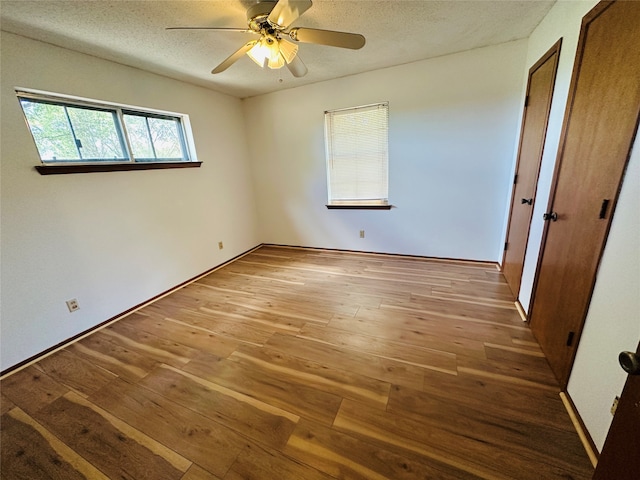 unfurnished room featuring ceiling fan, a textured ceiling, and hardwood / wood-style floors