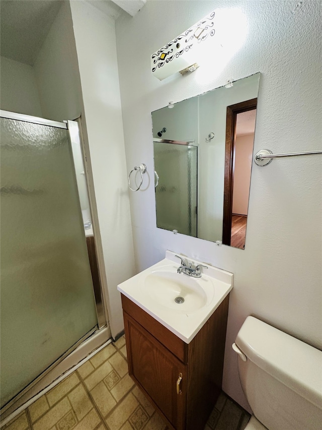 bathroom with an enclosed shower, vanity, and toilet