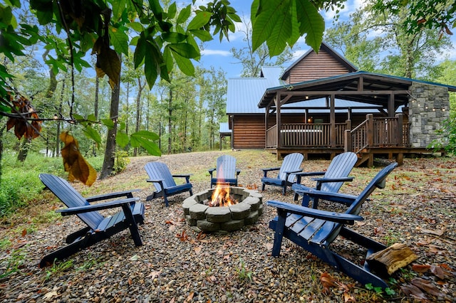 view of yard featuring a deck and an outdoor fire pit