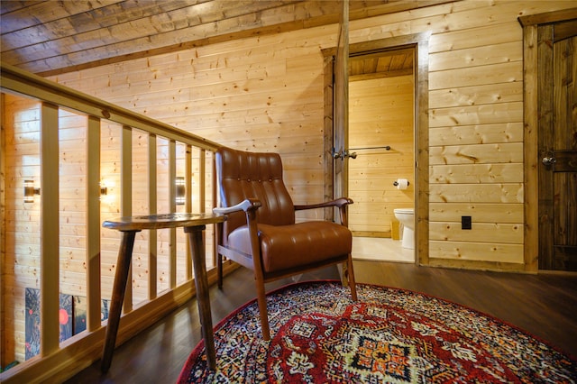 living area with wood walls and hardwood / wood-style floors