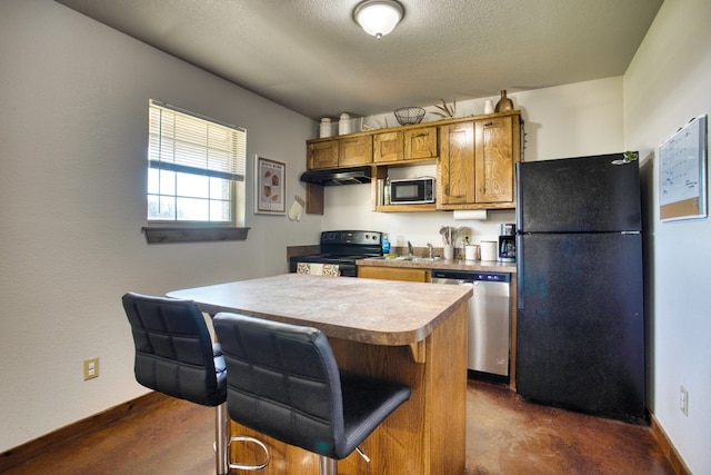 kitchen featuring sink, a breakfast bar, a textured ceiling, black appliances, and a center island