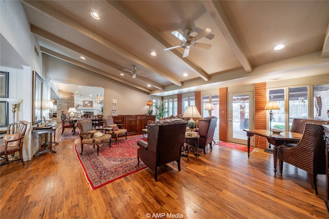 living room with ceiling fan, vaulted ceiling with beams, plenty of natural light, and hardwood / wood-style floors