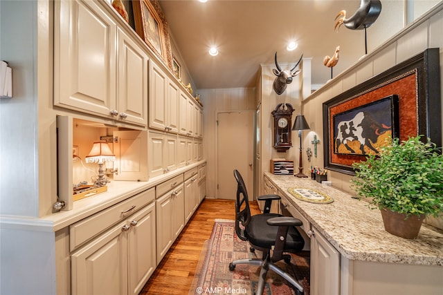 office featuring built in desk and light hardwood / wood-style floors