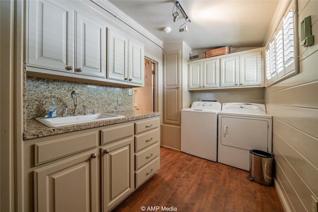 laundry room featuring cabinets, ornamental molding, dark hardwood / wood-style floors, washer and dryer, and sink