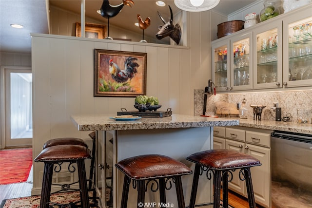 interior space featuring light stone countertops, dishwasher, light wood-type flooring, and a kitchen bar