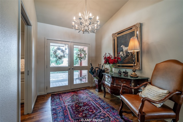 foyer entrance with french doors, vaulted ceiling, hardwood / wood-style flooring, and a notable chandelier