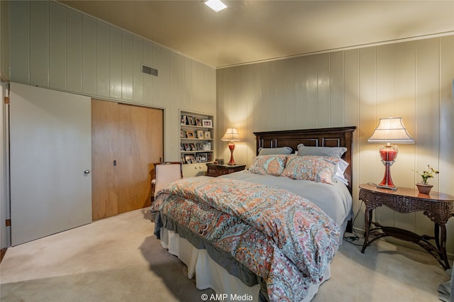 carpeted bedroom featuring wooden walls and a closet