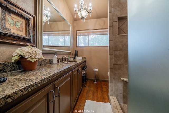 bathroom with a notable chandelier, vanity, hardwood / wood-style floors, and toilet