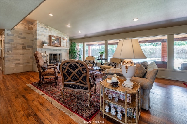 living room featuring lofted ceiling, hardwood / wood-style floors, plenty of natural light, and a fireplace