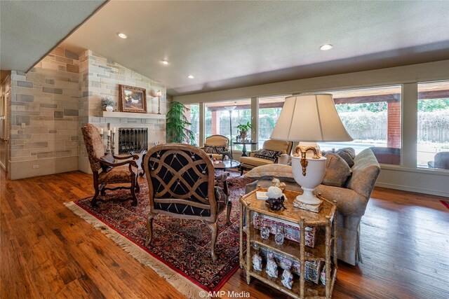 923 W Lake Dr, Hamlin, TX 79520 - living room with a large fireplace, vaulted ceiling, recessed lighting, and wood finished floors