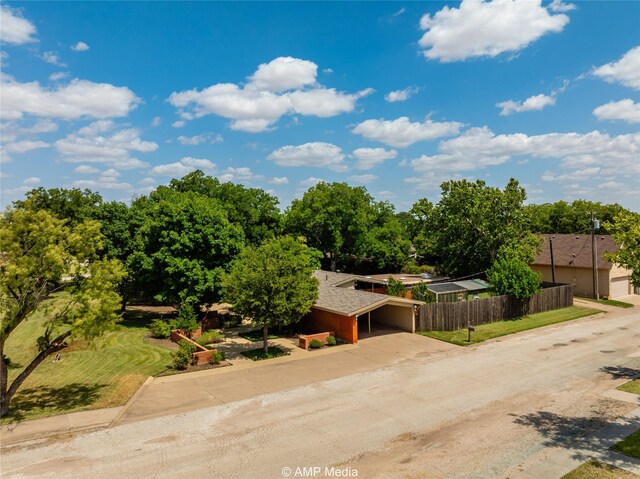 923 W Lake Dr, Hamlin, TX 79520 - view of front of house featuring concrete driveway, fence, and roof with shingles