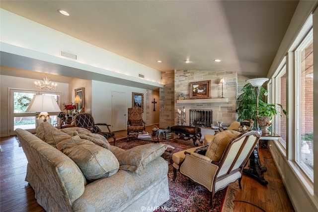 living room with an inviting chandelier, a large fireplace, lofted ceiling, and dark hardwood / wood-style flooring