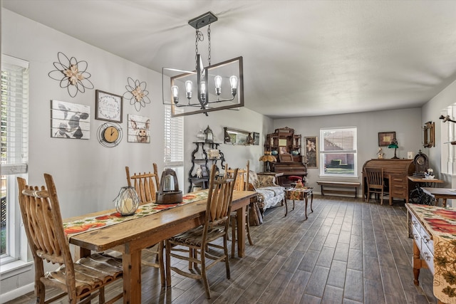 dining space with dark hardwood / wood-style floors and a notable chandelier