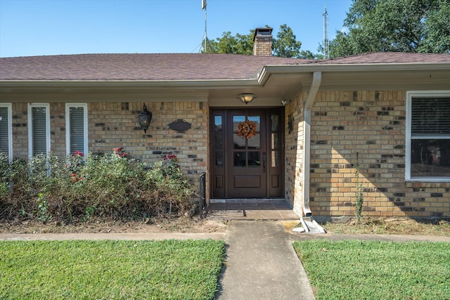 doorway to property featuring a lawn