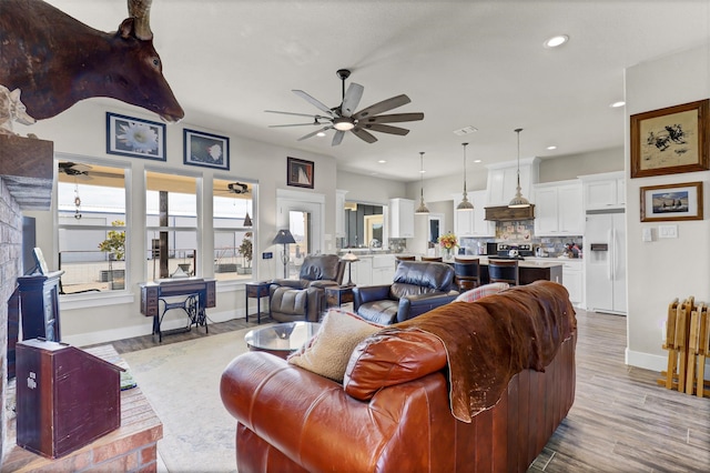 living room featuring ceiling fan and hardwood / wood-style floors