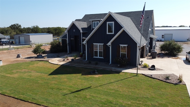 view of front of property with a front yard, an outdoor structure, and a garage