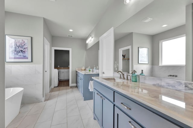 bathroom featuring vanity and a bath