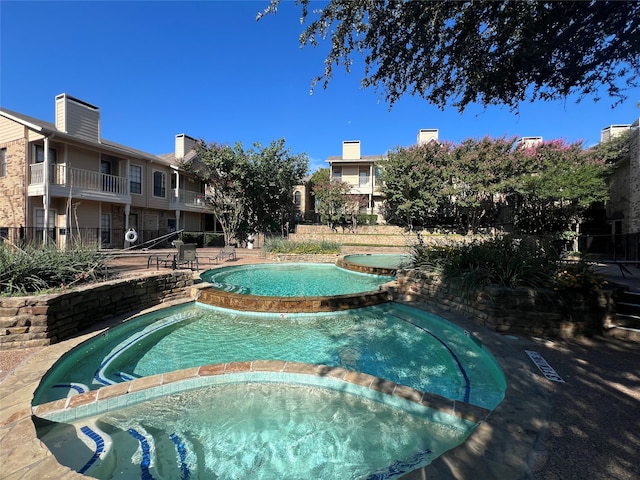 view of swimming pool with an in ground hot tub