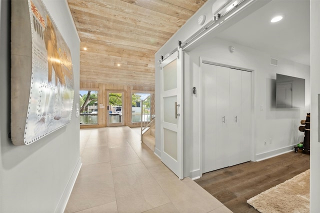 hall featuring wood ceiling, hardwood / wood-style flooring, lofted ceiling, a barn door, and built in features