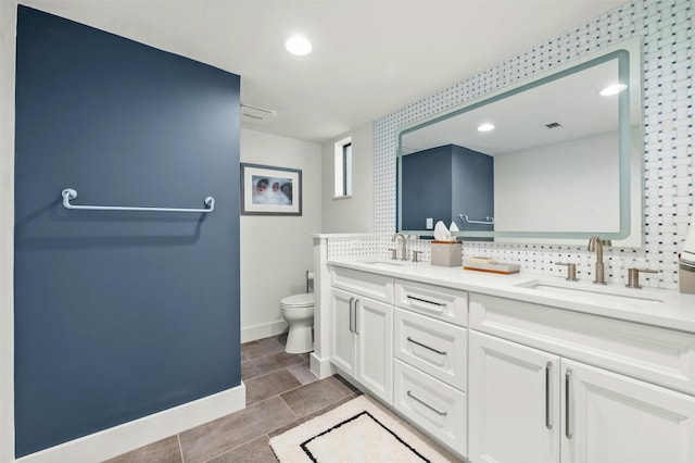 bathroom with tile patterned floors, tasteful backsplash, vanity, and toilet