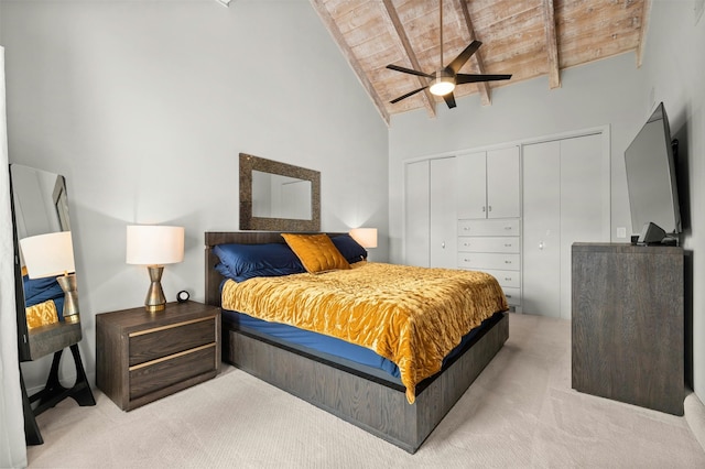 carpeted bedroom with ceiling fan, beamed ceiling, high vaulted ceiling, a closet, and wooden ceiling