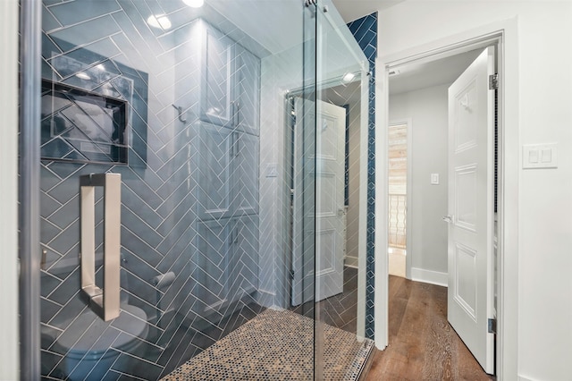 bathroom featuring a tile shower and hardwood / wood-style flooring