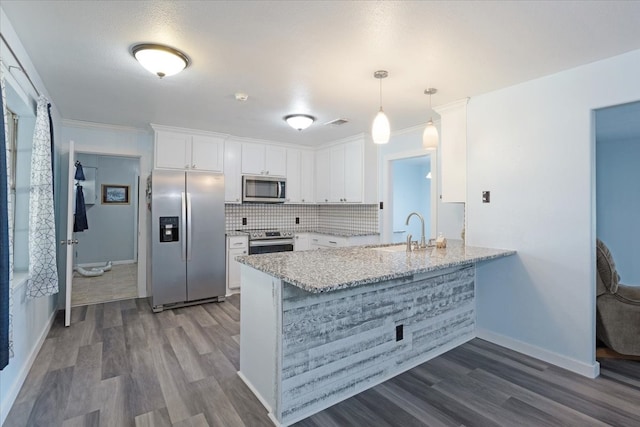 kitchen with dark wood-type flooring, white cabinetry, kitchen peninsula, appliances with stainless steel finishes, and decorative light fixtures