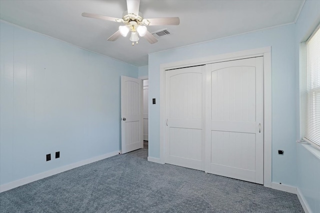 unfurnished bedroom featuring crown molding, carpet flooring, ceiling fan, and a closet