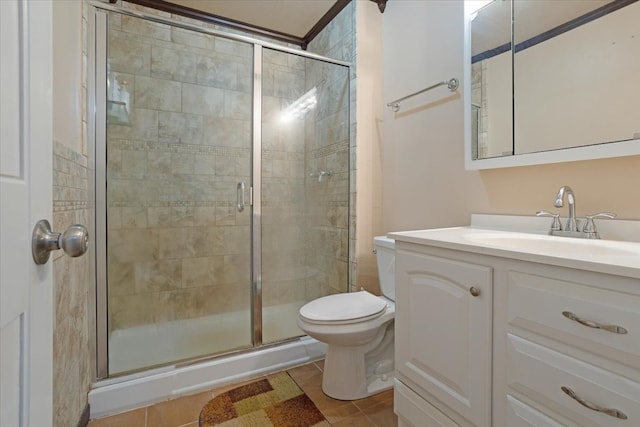 bathroom with tile patterned flooring, a shower with shower door, vanity, and toilet