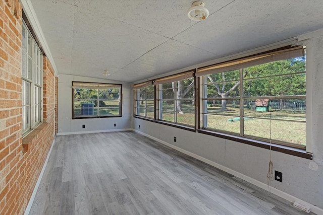 unfurnished sunroom featuring lofted ceiling