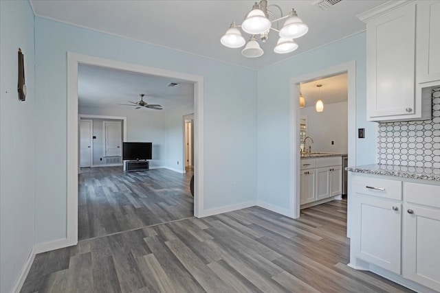 kitchen featuring decorative backsplash, white cabinetry, ceiling fan with notable chandelier, hardwood / wood-style flooring, and decorative light fixtures