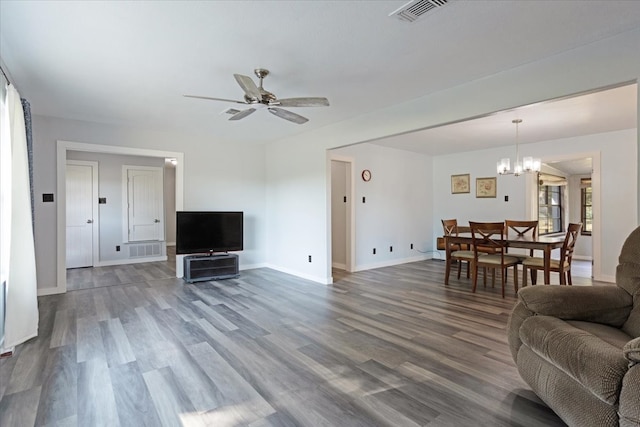 living room with ceiling fan with notable chandelier and hardwood / wood-style floors