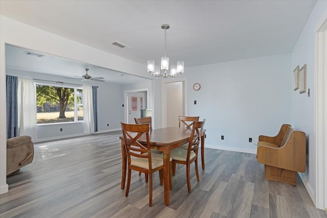 dining area with ceiling fan with notable chandelier and hardwood / wood-style floors