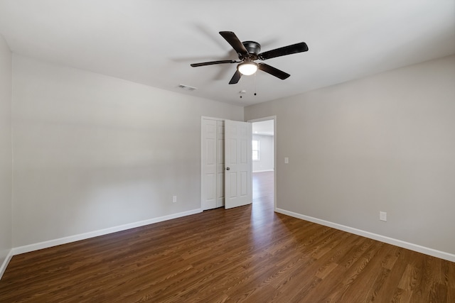 unfurnished room featuring dark wood-type flooring and ceiling fan