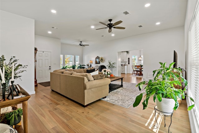 living room with light hardwood / wood-style floors and ceiling fan