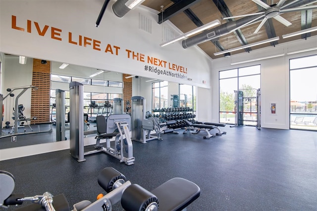 exercise room with ceiling fan and high vaulted ceiling