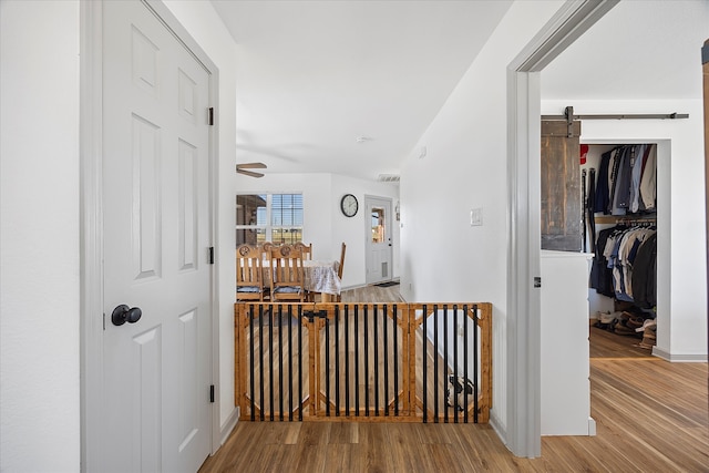 hall featuring a barn door and hardwood / wood-style flooring