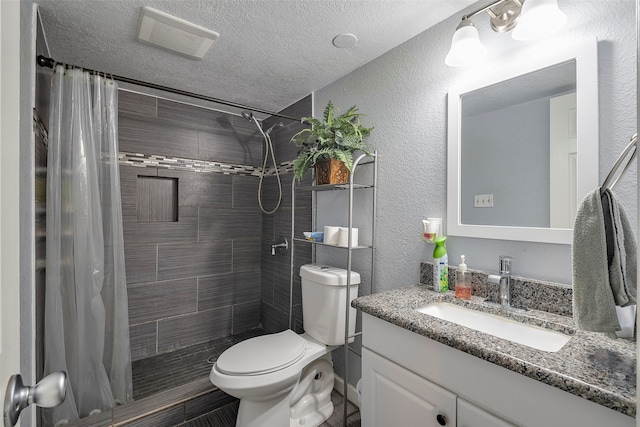 bathroom with a textured ceiling, vanity, toilet, and a shower with curtain