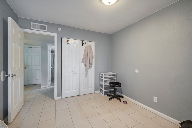 unfurnished bedroom with light tile patterned floors and a closet