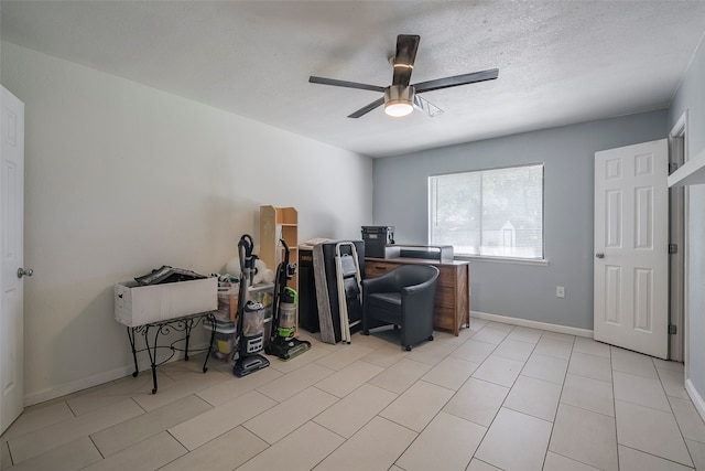 home office with a textured ceiling, light tile patterned flooring, and ceiling fan